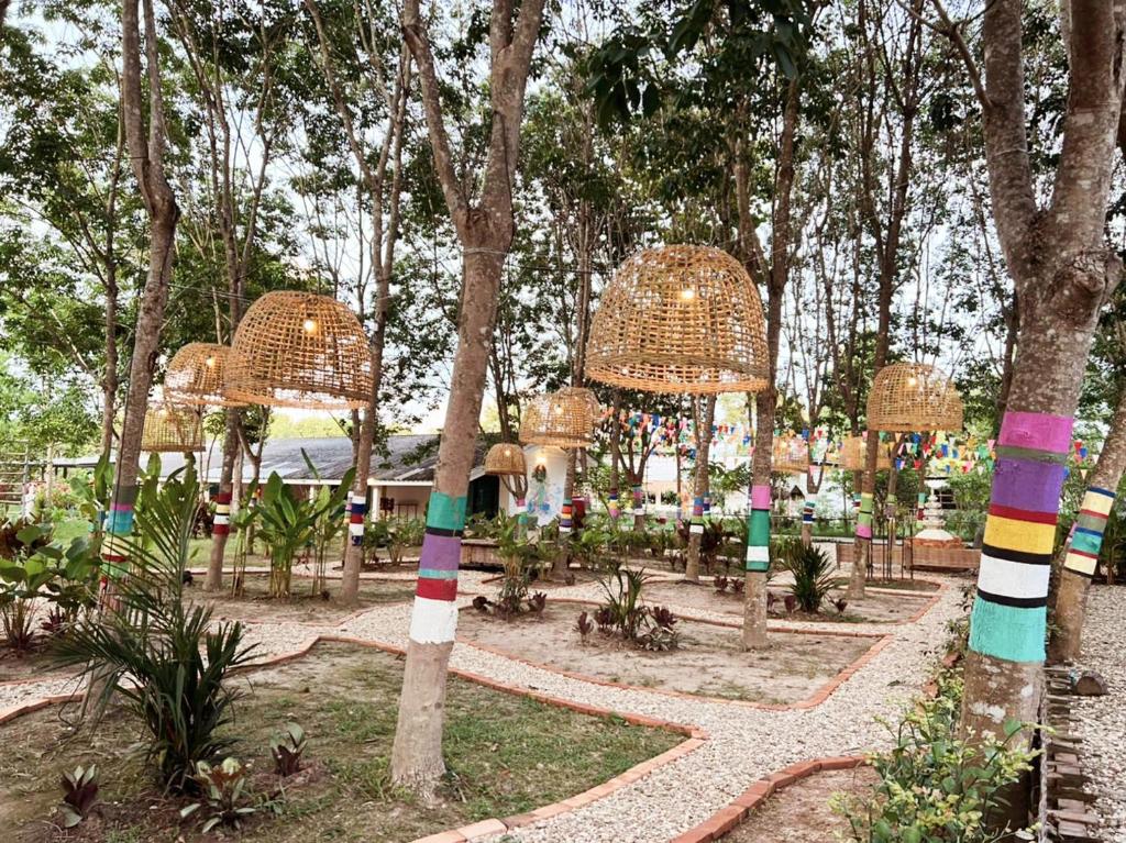 een park met bomen en kleurrijke gestreepte palen bij ฮักฮิมเกี๋ยน รีสอร์ท น่าน Hug Him Kien in Nan
