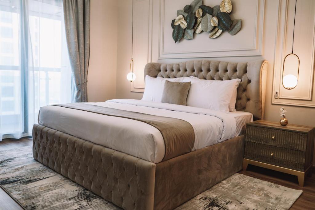 - une chambre avec un grand lit et une grande tête de lit dans l'établissement Two Continents Holiday Homes - Penthouse on 71st floor - Princess Tower, à Dubaï