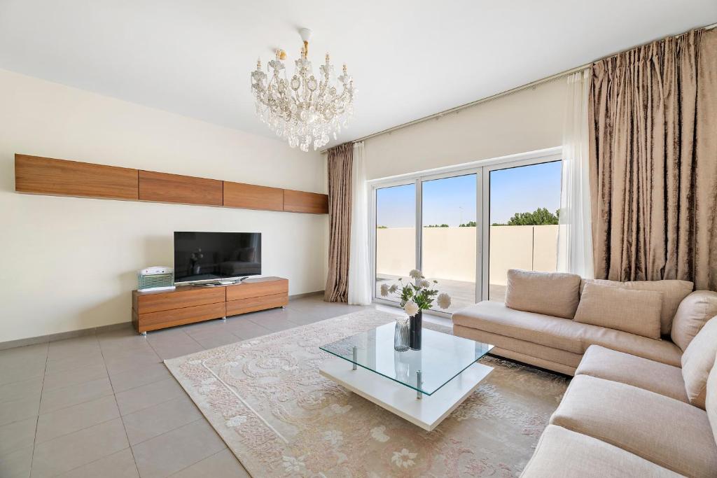 a living room with a couch and a coffee table at Spacious & Private Townhome - 5 mins drive to Al Maktoum Airport in Dubai