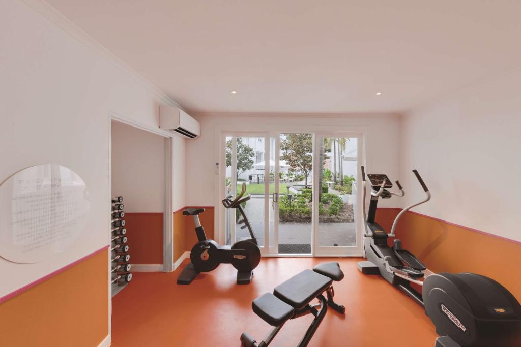 a gym with treadmills and ellipticals in a room at Adina Apartment Hotel Chippendale in Sydney