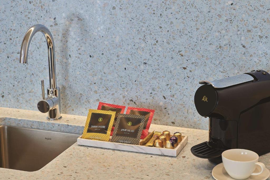 a coffee maker sitting on a kitchen counter next to a sink at Adina Apartment Hotel Chippendale in Sydney