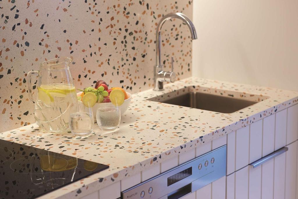 a kitchen counter with a bowl of fruit and a sink at Adina Apartment Hotel Chippendale in Sydney