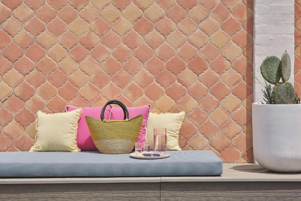 a bench with pillows and a purse on it at Adina Apartment Hotel Chippendale in Sydney