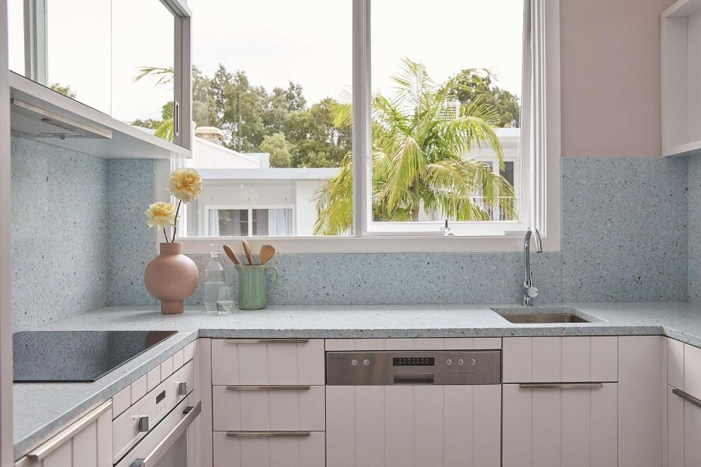 a kitchen with white cabinets and a window and a sink at Adina Apartment Hotel Chippendale in Sydney