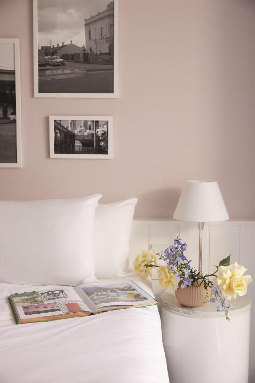 a bedroom with a bed with a book and flowers on it at Adina Apartment Hotel Chippendale in Sydney
