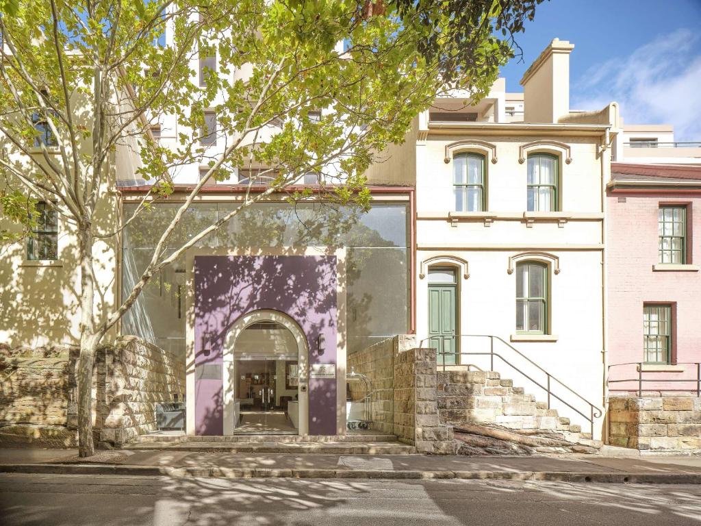 una entrada a un edificio blanco con una puerta morada en Rendezvous Hotel Sydney The Rocks en Sídney