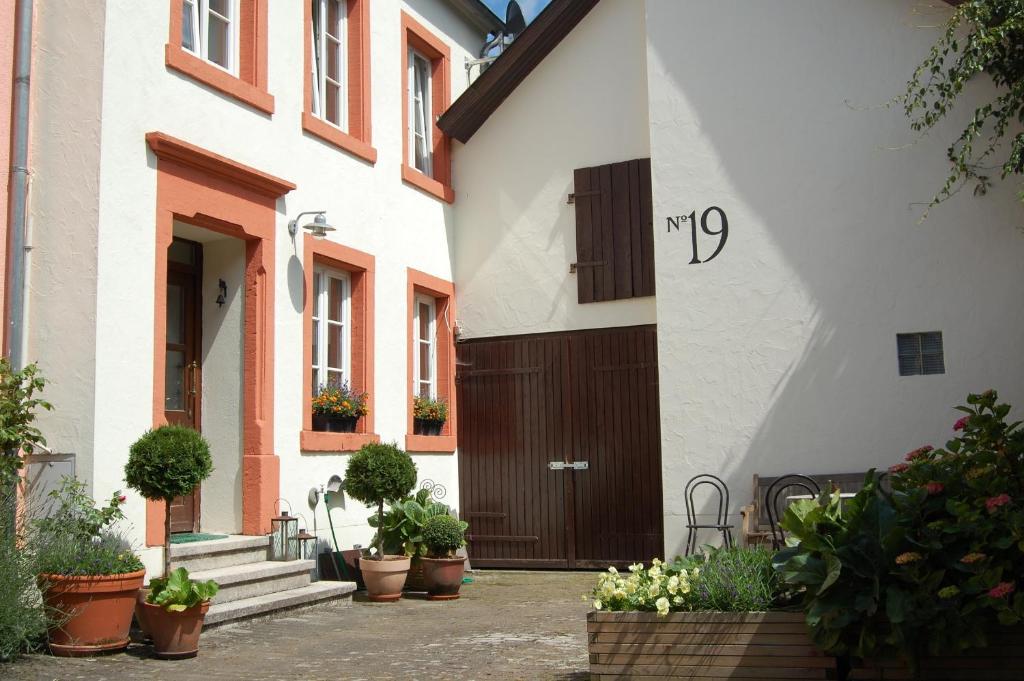 a white building with a brown door and some plants at Gartenhaus - a68978 