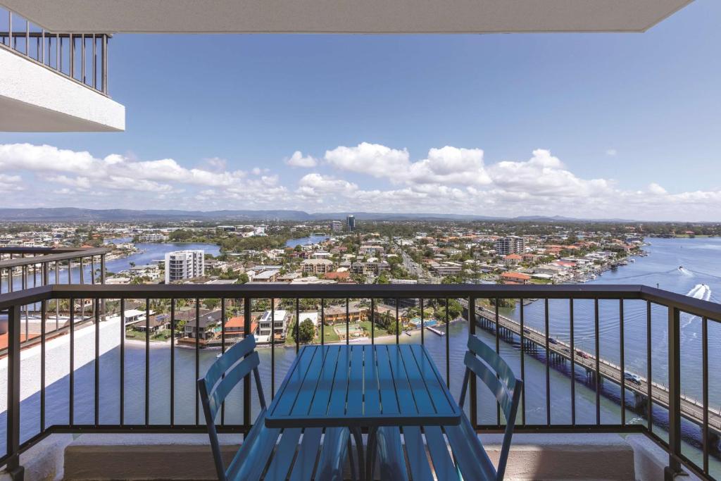 a blue bench on a balcony with a view of the water at Vibe Hotel Gold Coast in Gold Coast