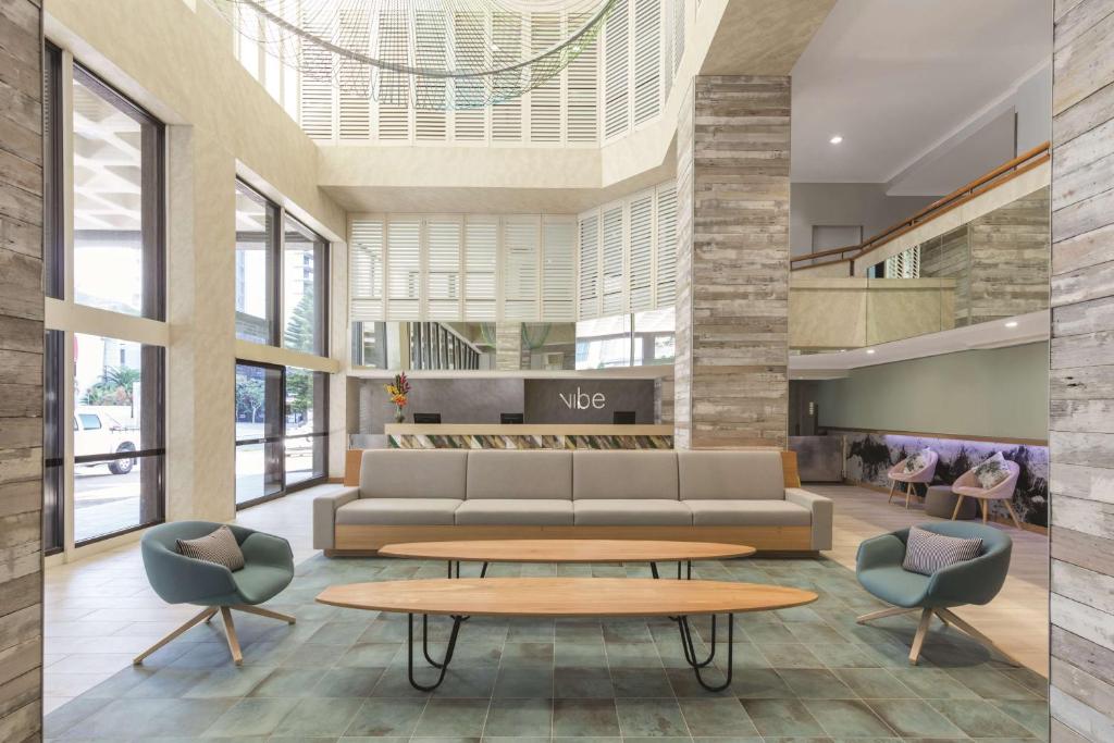 a lobby with a couch and chairs and a table at Vibe Hotel Gold Coast in Gold Coast