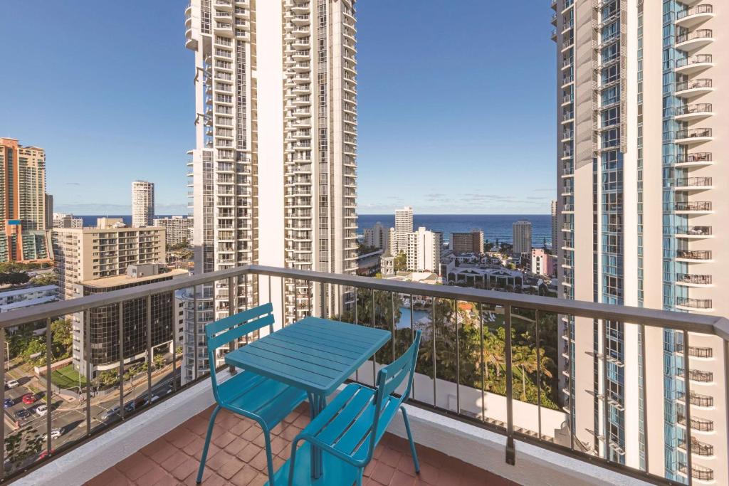 a blue table and two chairs on a balcony at Vibe Hotel Gold Coast in Gold Coast