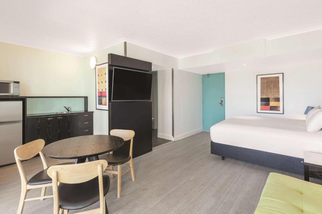 a hotel room with a bed and a table and chairs at Vibe Hotel Gold Coast in Gold Coast