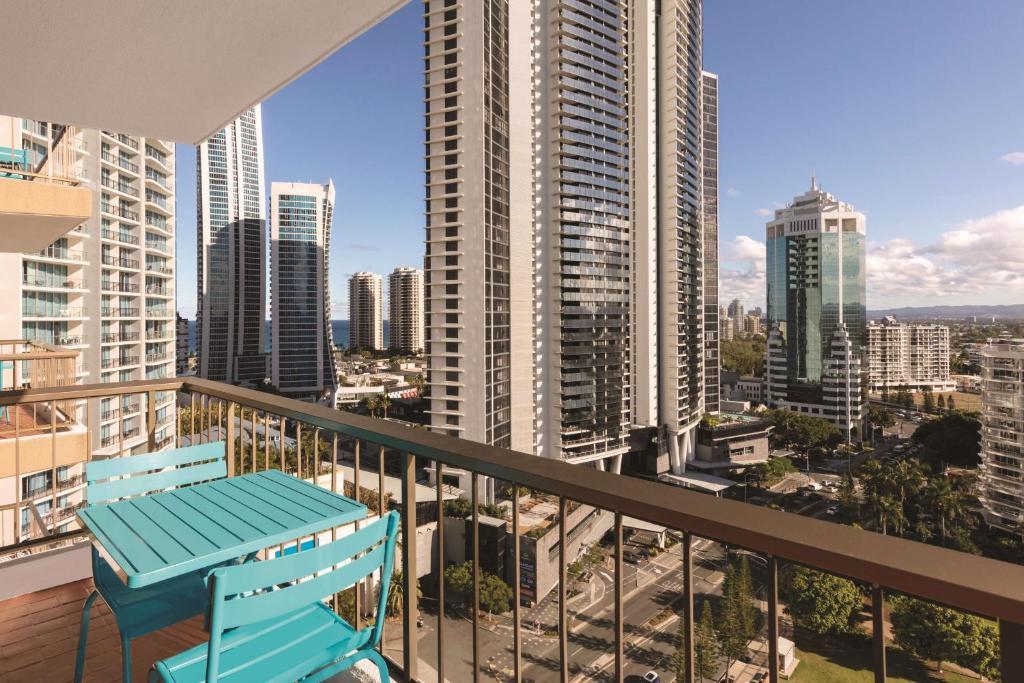 a balcony with a blue chair and a view of a city at Vibe Hotel Gold Coast in Gold Coast
