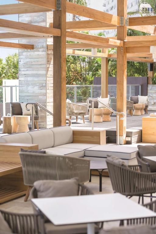 a patio with couches and tables and chairs at Vibe Hotel Gold Coast in Gold Coast