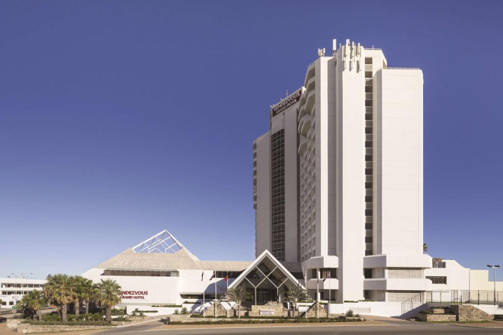 a large white building in front of a building at Rendezvous Hotel Perth Scarborough in Perth