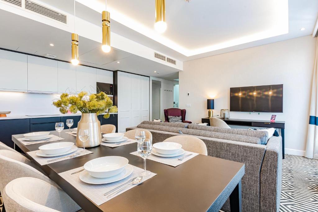 a dining room with a table and chairs and a couch at VacationClub - Baltic Park Fort Apartament G.508 in Świnoujście