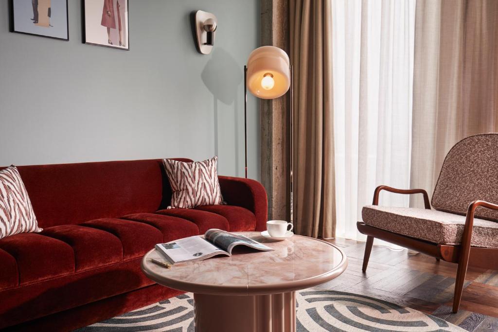 a living room with a red couch and a table at The Hoxton, Brussels in Brussels