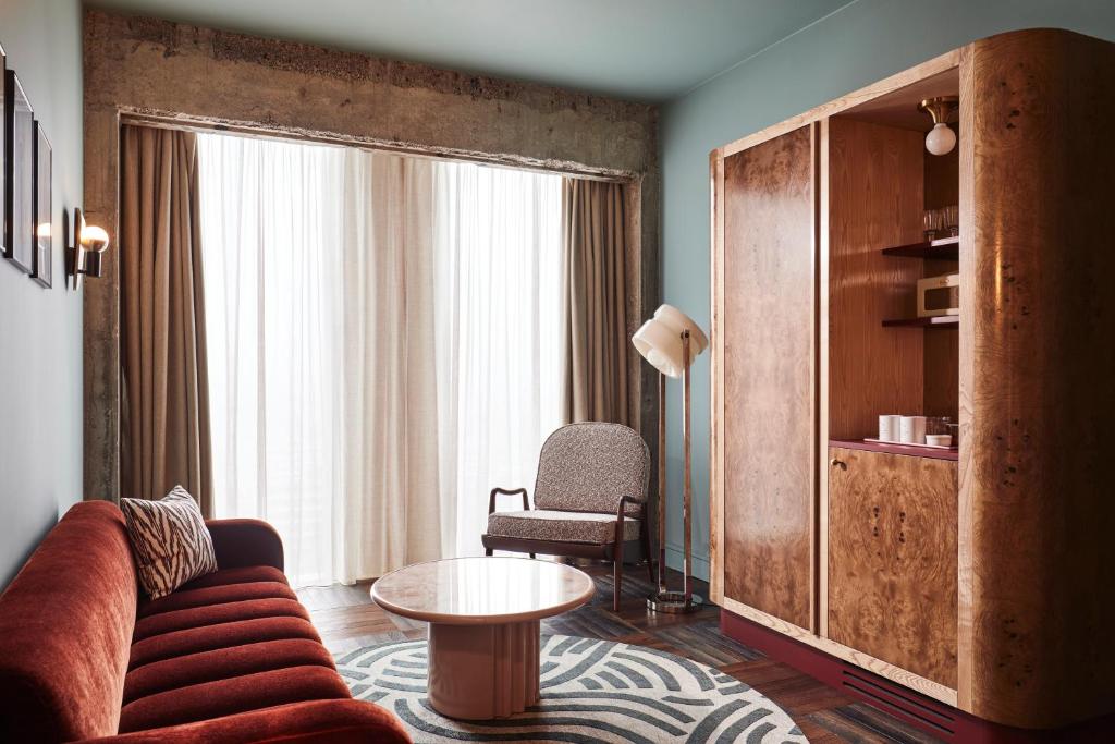 a living room with a couch and a table at The Hoxton, Brussels in Brussels