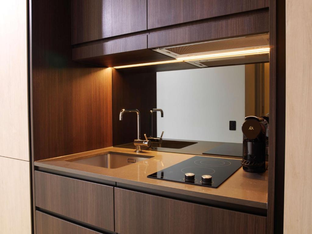 a kitchen with a sink and a mirror at A by Adina Sydney in Sydney