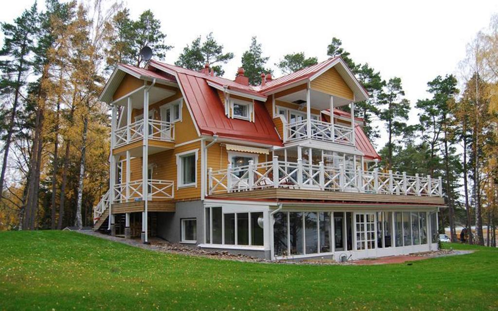 ein großes Haus mit rotem Dach auf einem grünen Feld in der Unterkunft Villa Harald - Beachfront in Hitis