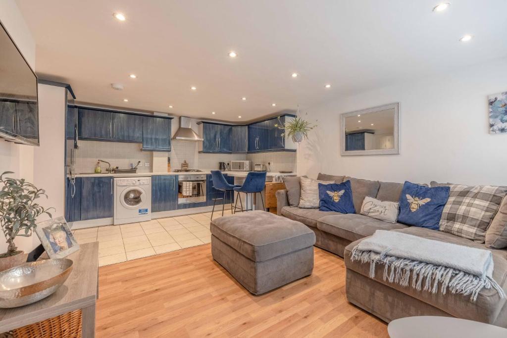 a living room with a couch and a kitchen at Windsor centre Parkview in Windsor