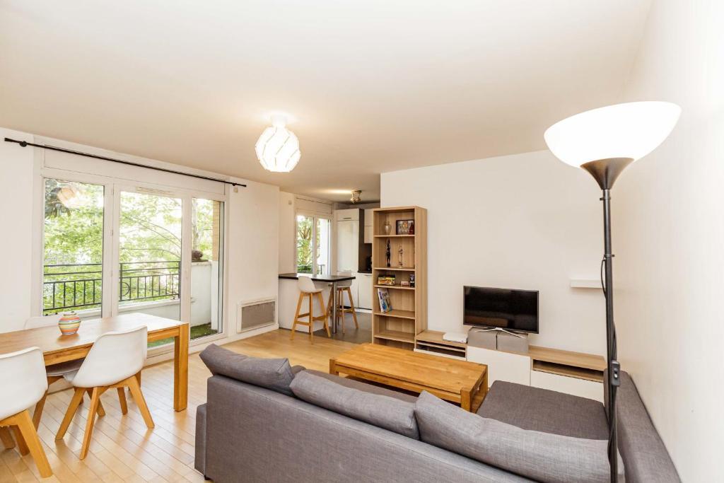 a living room with a couch and a table at Large apartment near Bois de Vincennes in Charenton-le-Pont