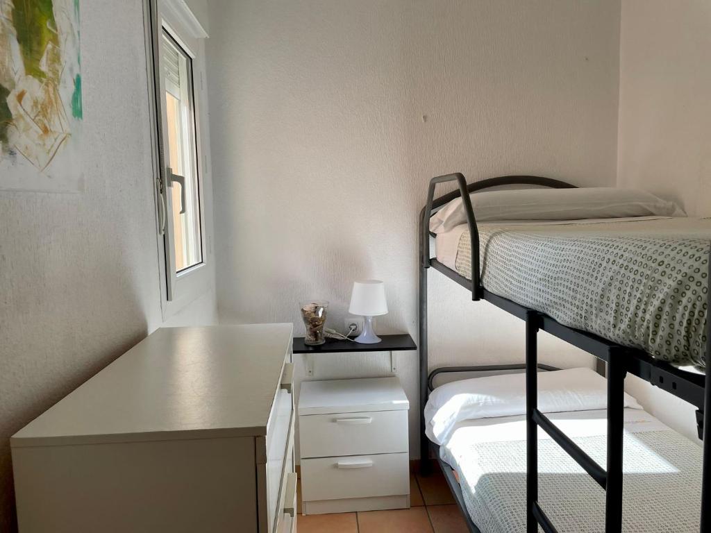 a small bedroom with a bunk bed and a desk at Apartamento Gaviotas Sureñas in Tarifa