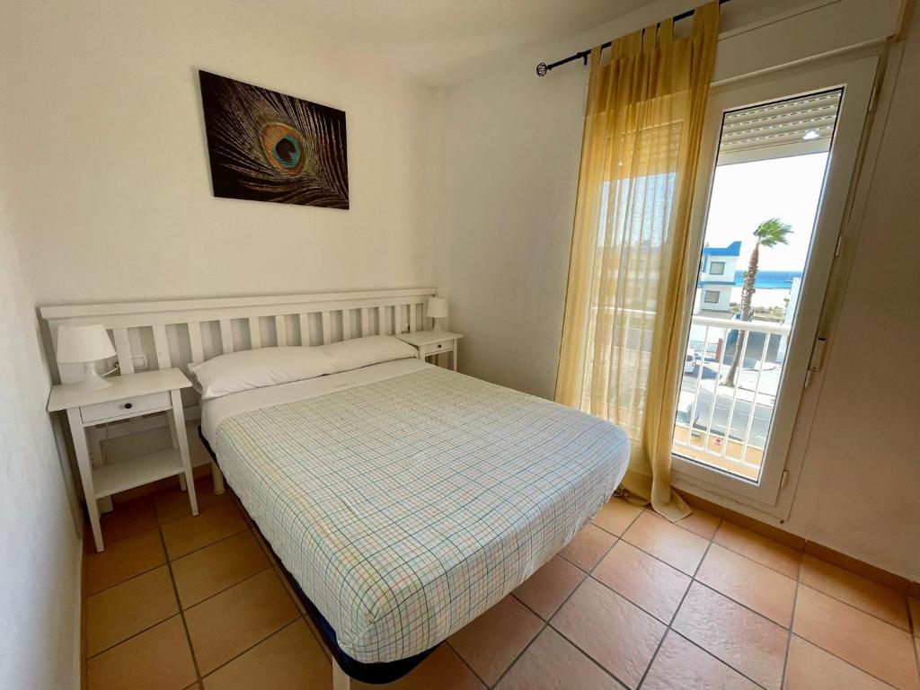 a small bedroom with a bed and a window at Apartamento Gaviotas Sureñas in Tarifa