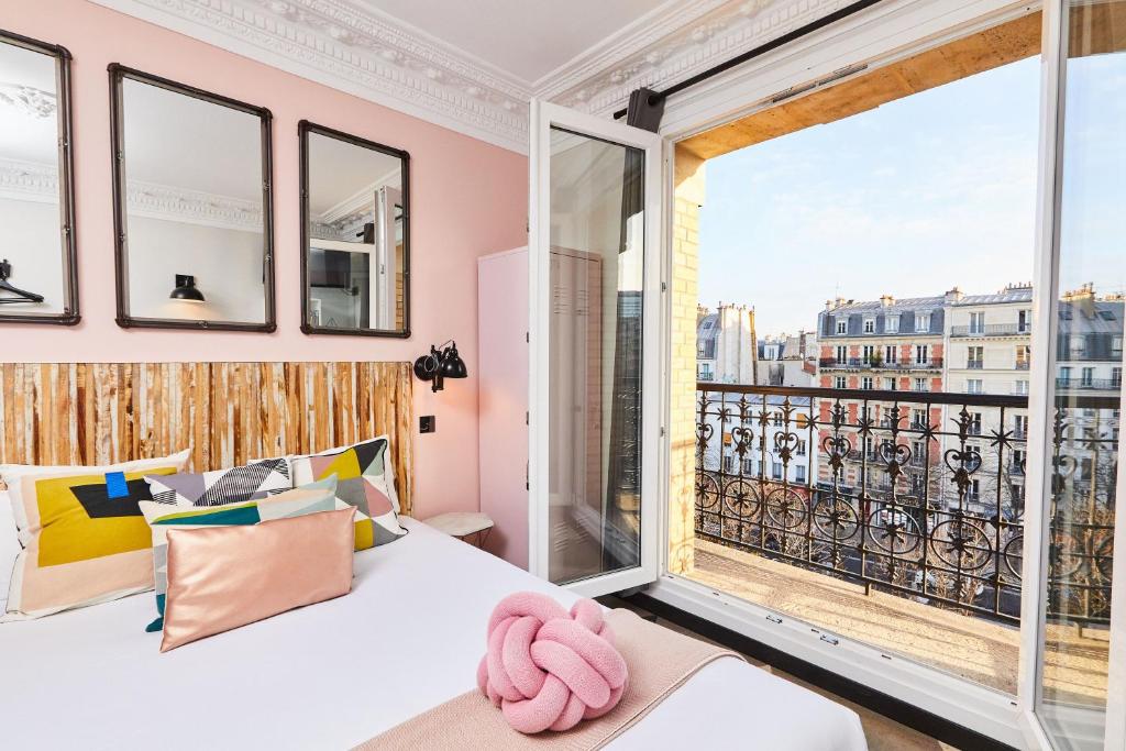 a bedroom with a bed and a large window at Madrigal in Paris