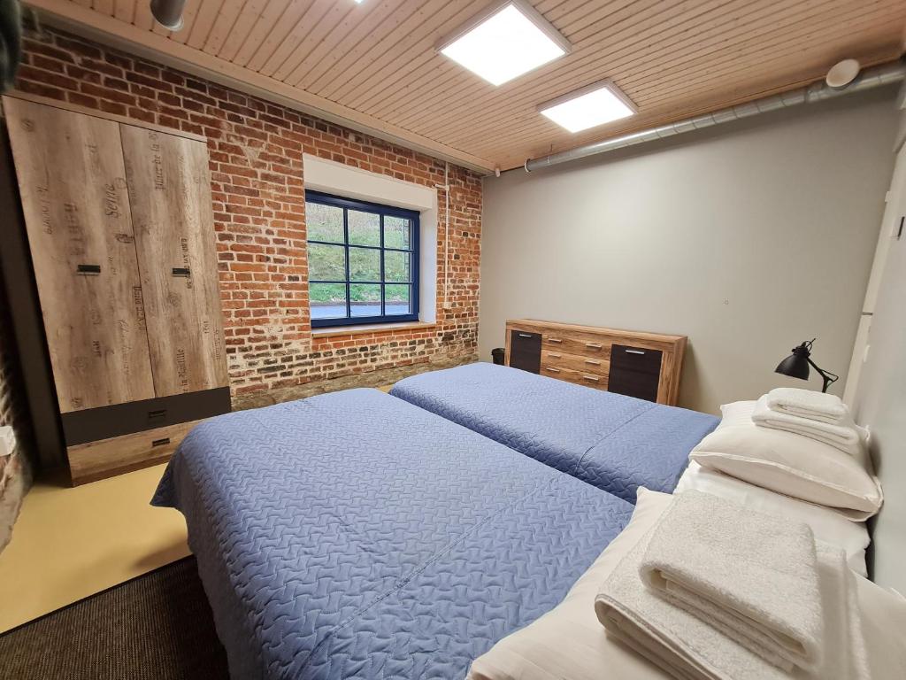 a bedroom with two beds and a brick wall at Narva Port Hostel in Narva