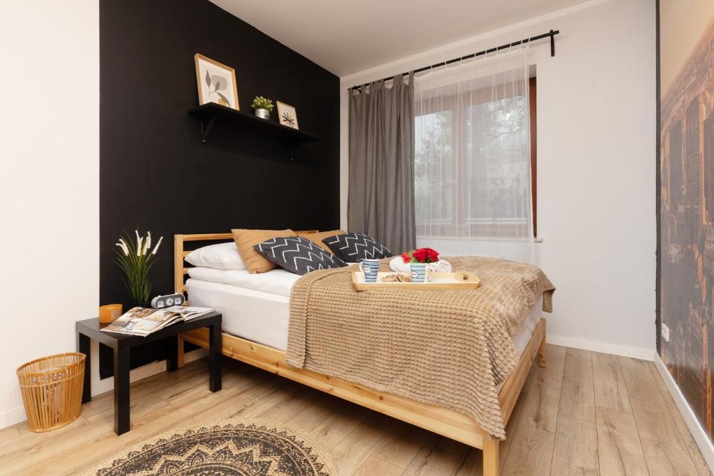 a bedroom with a bed and a table with flowers on it at Warsaw Mokotów Apartments ABC by Renters in Warsaw