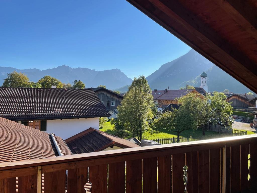 a view from a balcony of a town with mountains at Dachgeschosswohnung mit traumhaftem Zugspitzblick bei Garmisch in Farchant