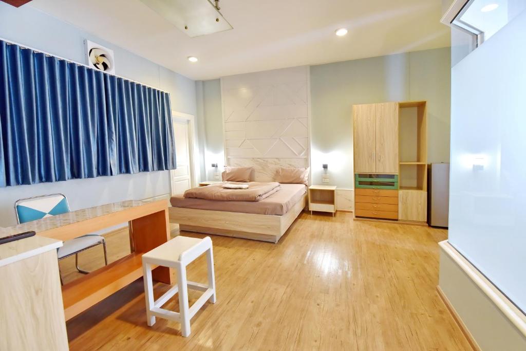 een slaapkamer met een bed en een bureau in een kamer bij 97 Merryland Apartments & Hotel in Ban Bang Samak