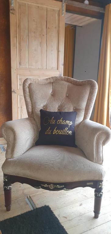 a brown couch with a blue pillow on it at Gite wellness Au champ du bouillon proche de Pairi Daiza et de la ville Ath 