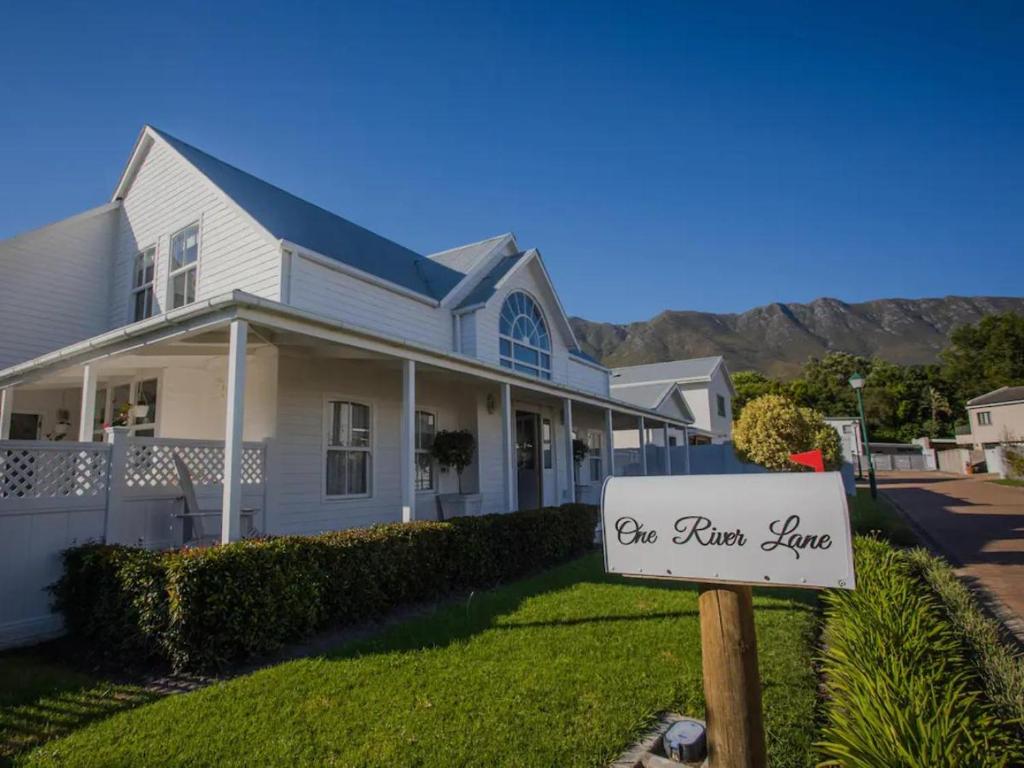 a house with a sign in front of it at Riverside Country House in Swellendam