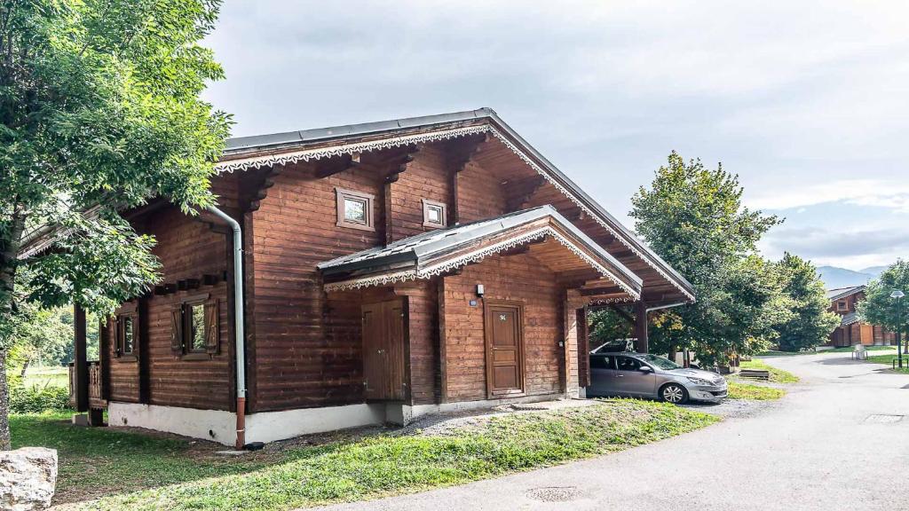 una casa in legno con un'auto parcheggiata di fronte di Bois de Champelle- 94 Magnifique Chalet-10 pers a Morillon