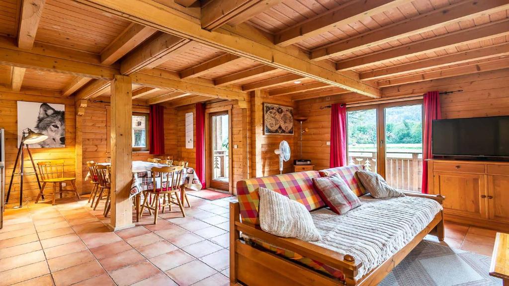 salon z kanapą i telewizorem w kabinie w obiekcie Bois de Champelle- 94 Magnifique Chalet-10 pers w mieście Morillon