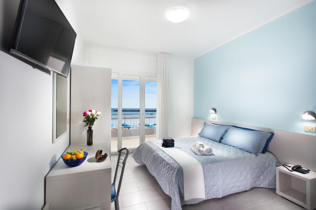 a bedroom with a bed with a view of the ocean at Hotel Platinum in Rimini