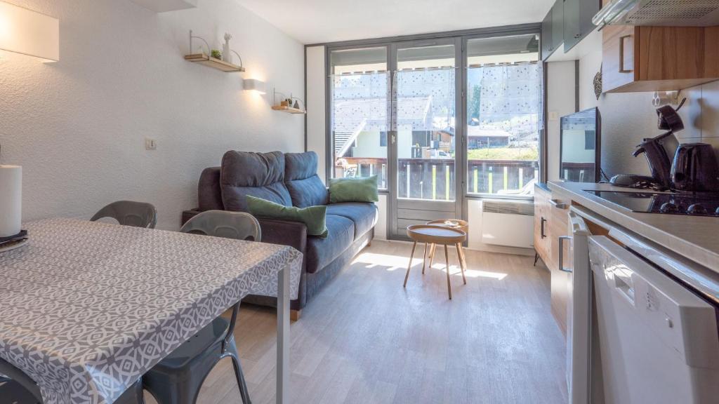 uma cozinha e sala de estar com um sofá e uma mesa em Grand Morillon - 104 - Montagne Belle Vue Studio 4 em Morillon