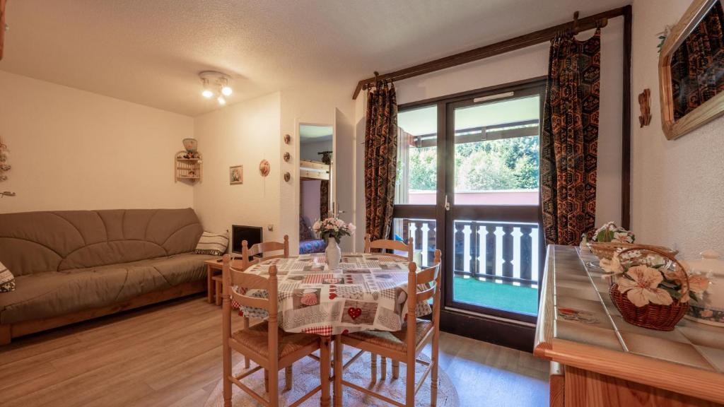 sala de estar con mesa y sofá en Le Grand Neige - 36 - Appart Montagne 6 pers en Morillon