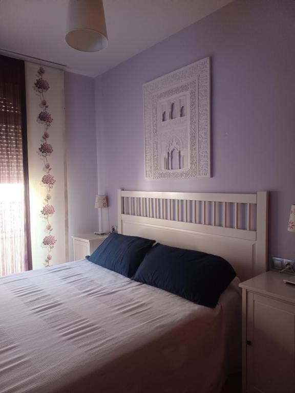 um quarto com uma cama grande e uma cabeceira branca em PLAZA NUEVA em Serra Nevada