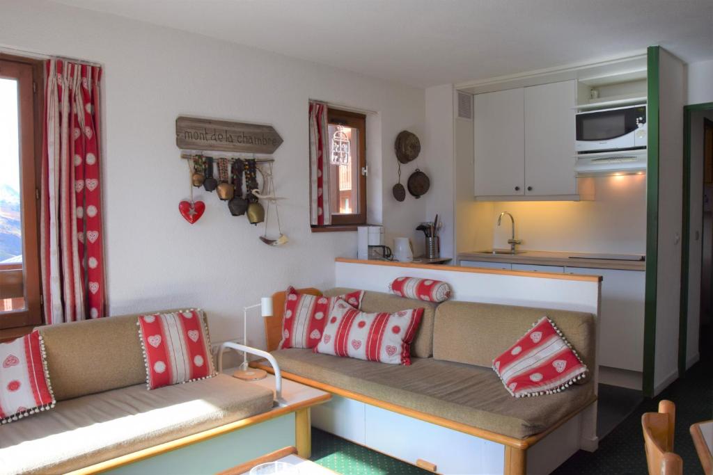 a living room with two couches and a kitchen at Necou 721 in Les Menuires