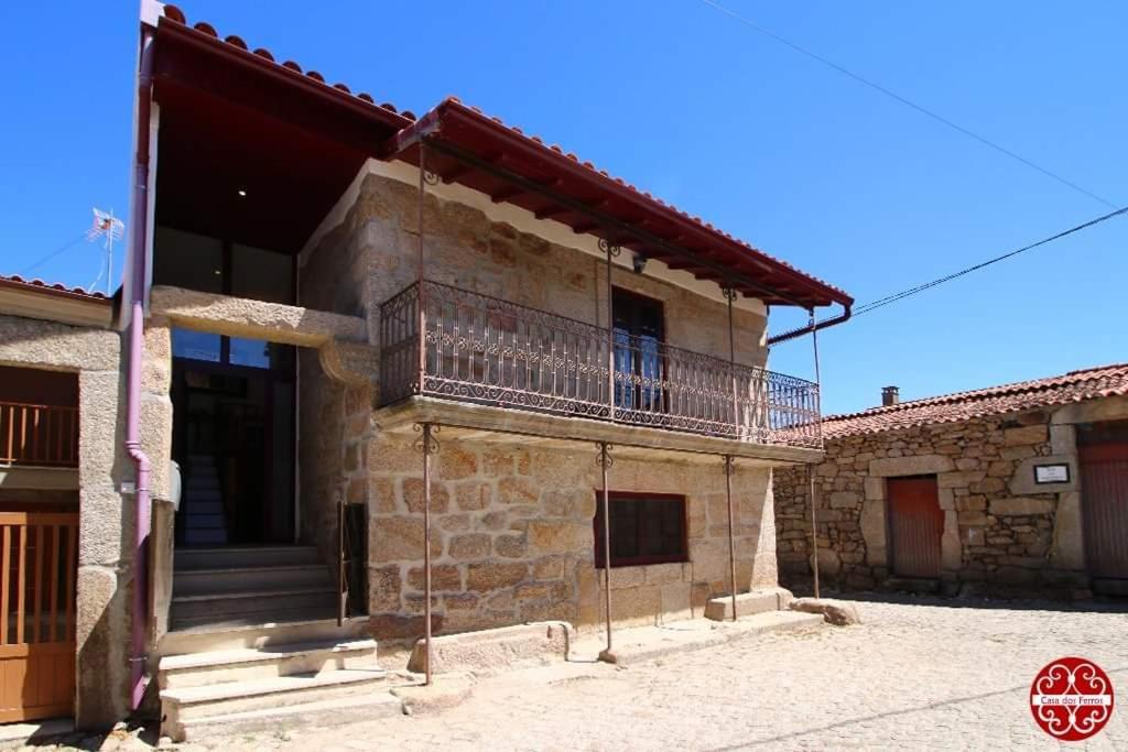 an old stone house with a balcony on it at Casa dos Ferros 