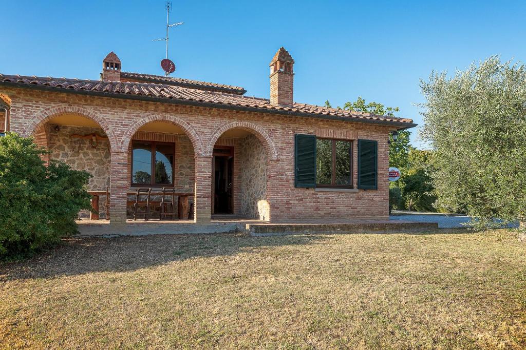 ein Backsteinhaus mit einem Hof davor in der Unterkunft Villa Verde in Lucignano