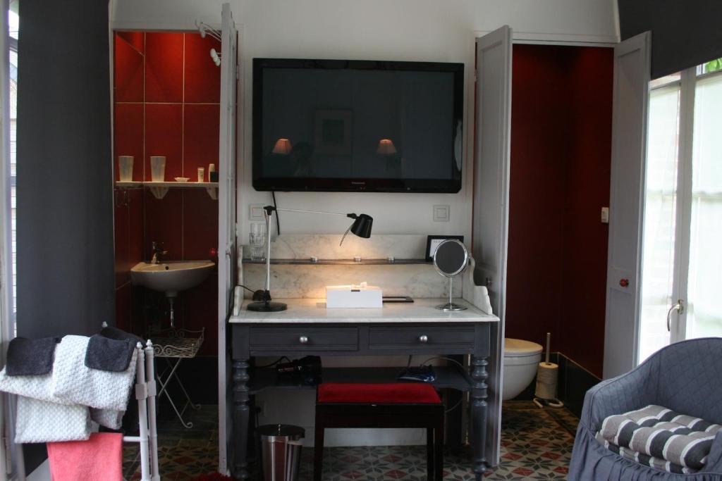 a living room with a tv on a wall at Aux Rives de Honfleur in Berville-sur-Mer