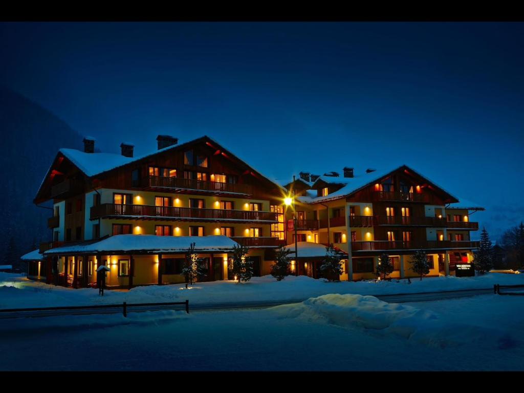a large building in the snow at night at Appartamento Jardin des Alpes. in La Thuile