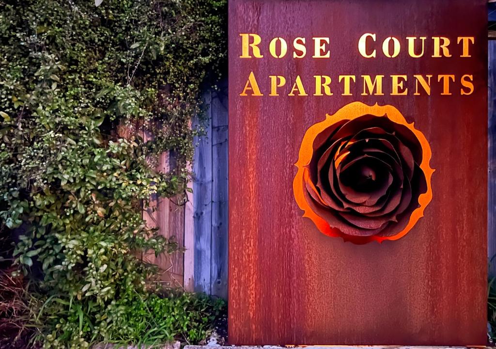 un panneau rouge avec une fleur sur lui dans l'établissement Hobart Rose Court Apartments "Avitium", à New Town