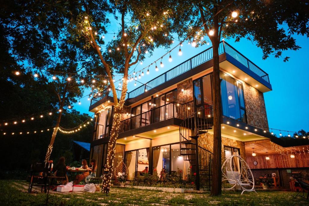 uma casa iluminada à noite com luzes de Natal em Moon Villa Soc Son - Venuestay em Hanói