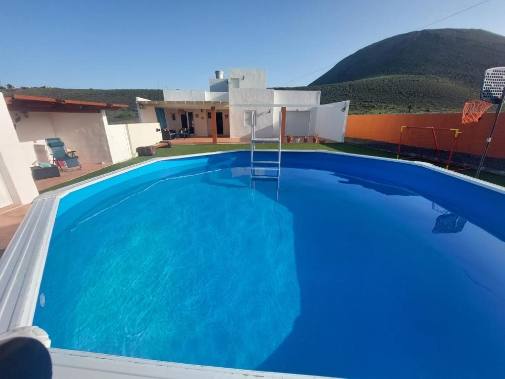 a large blue swimming pool in front of a house at CASA LITO in Haría