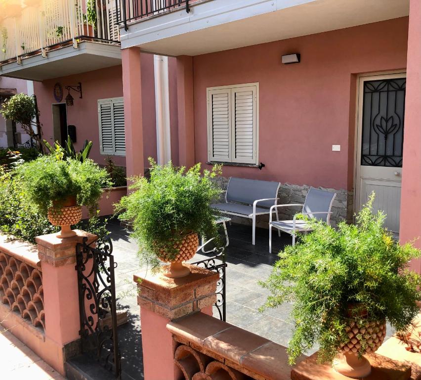 a patio of a house with potted plants at La Ginestra in Giardini Naxos