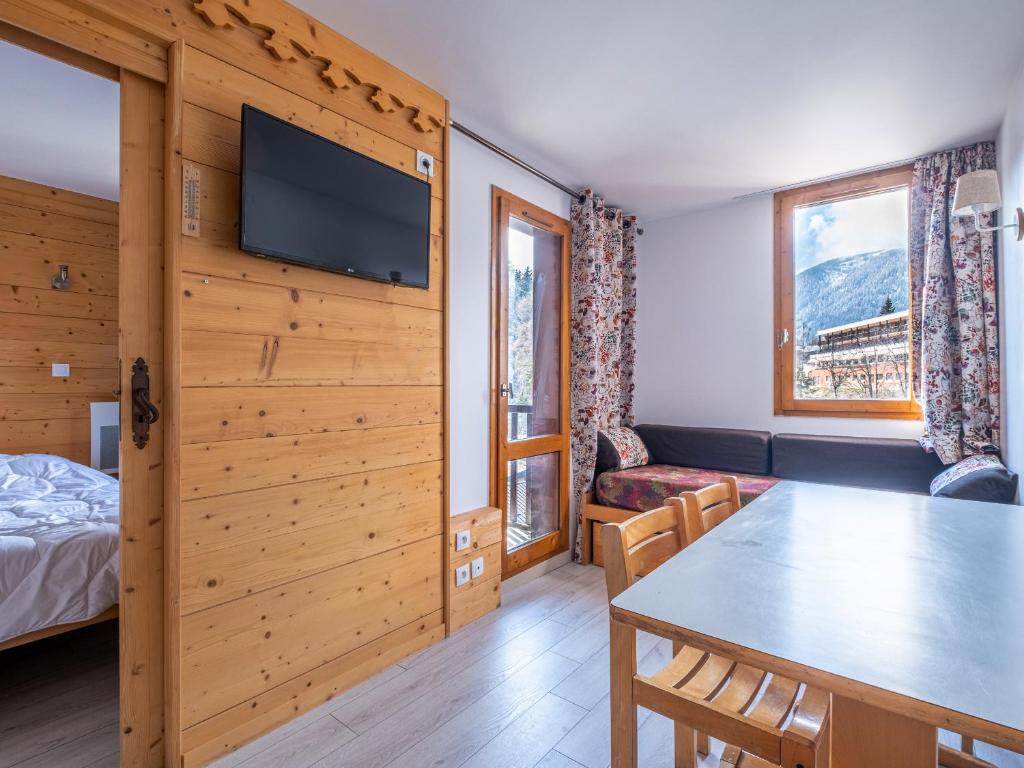 a room with a table and a bed and a tv at Arcades-48- Studio pied des pistes-3 pers in Doucy